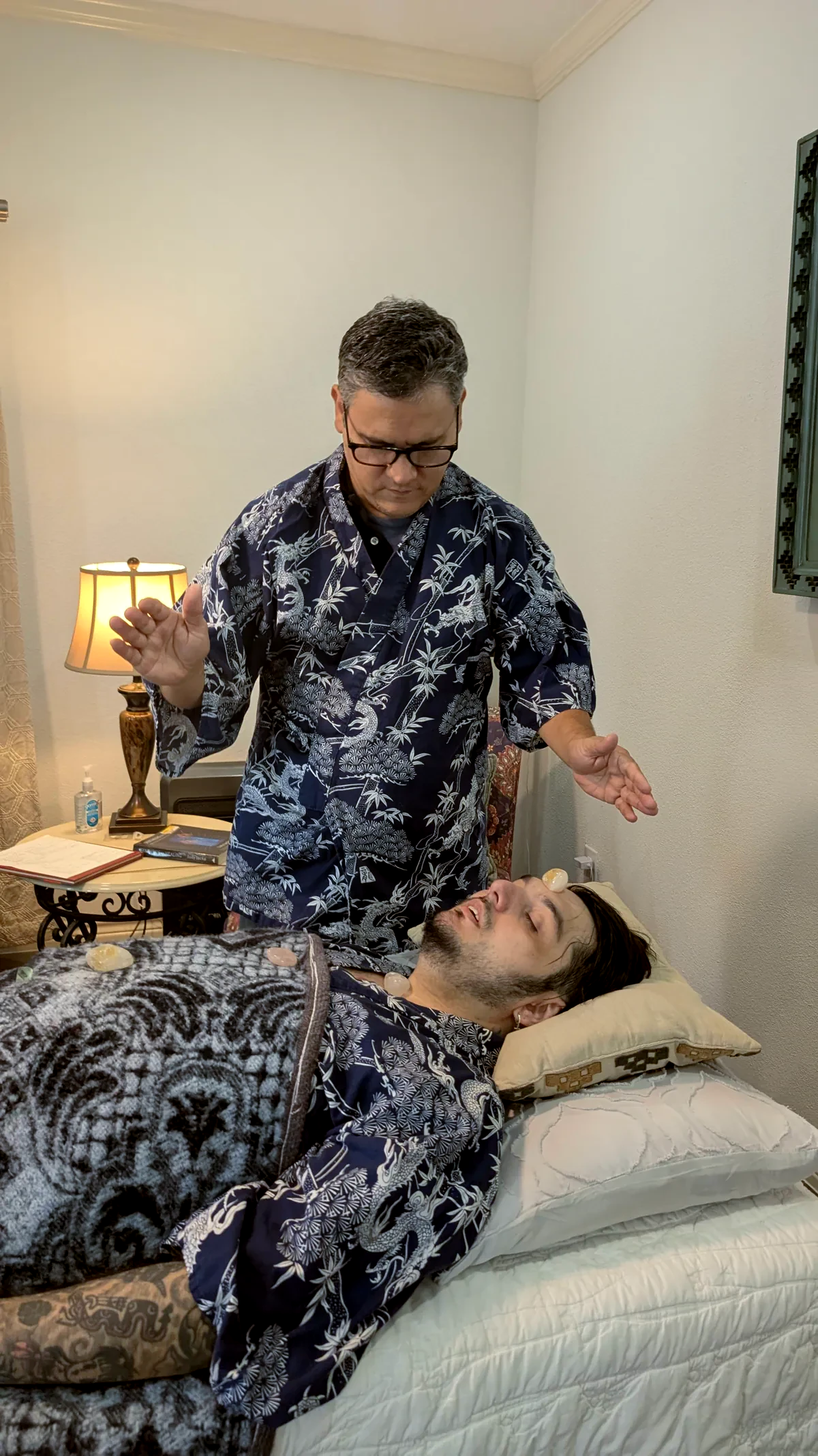 Fernando performing Reiki with a client in Madre Tierra’s warmly lit treatment room