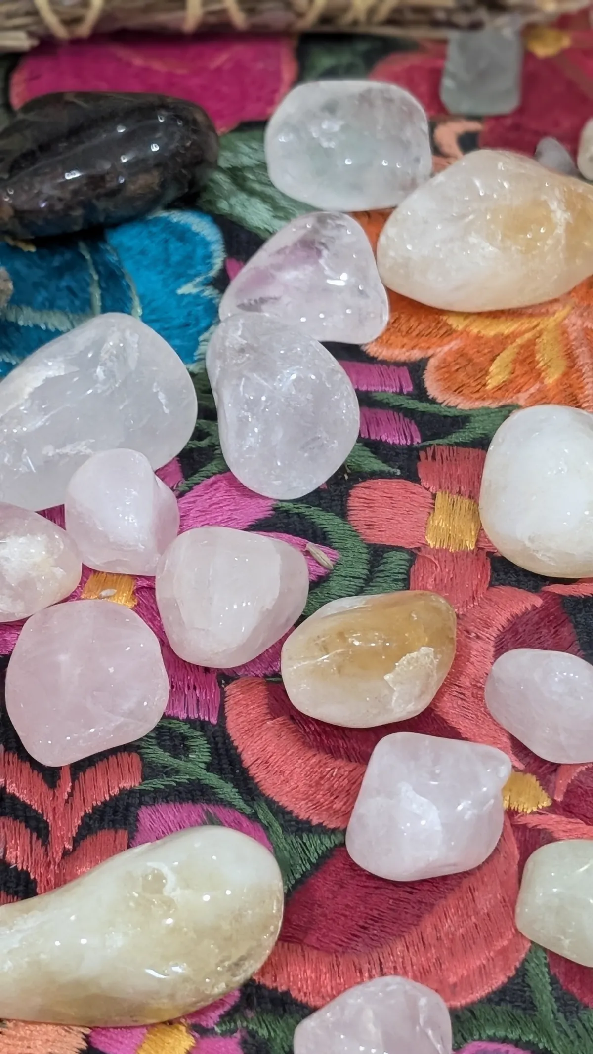 Close-up of polished stones on a colorful embroidered cloth at Madre Tierra