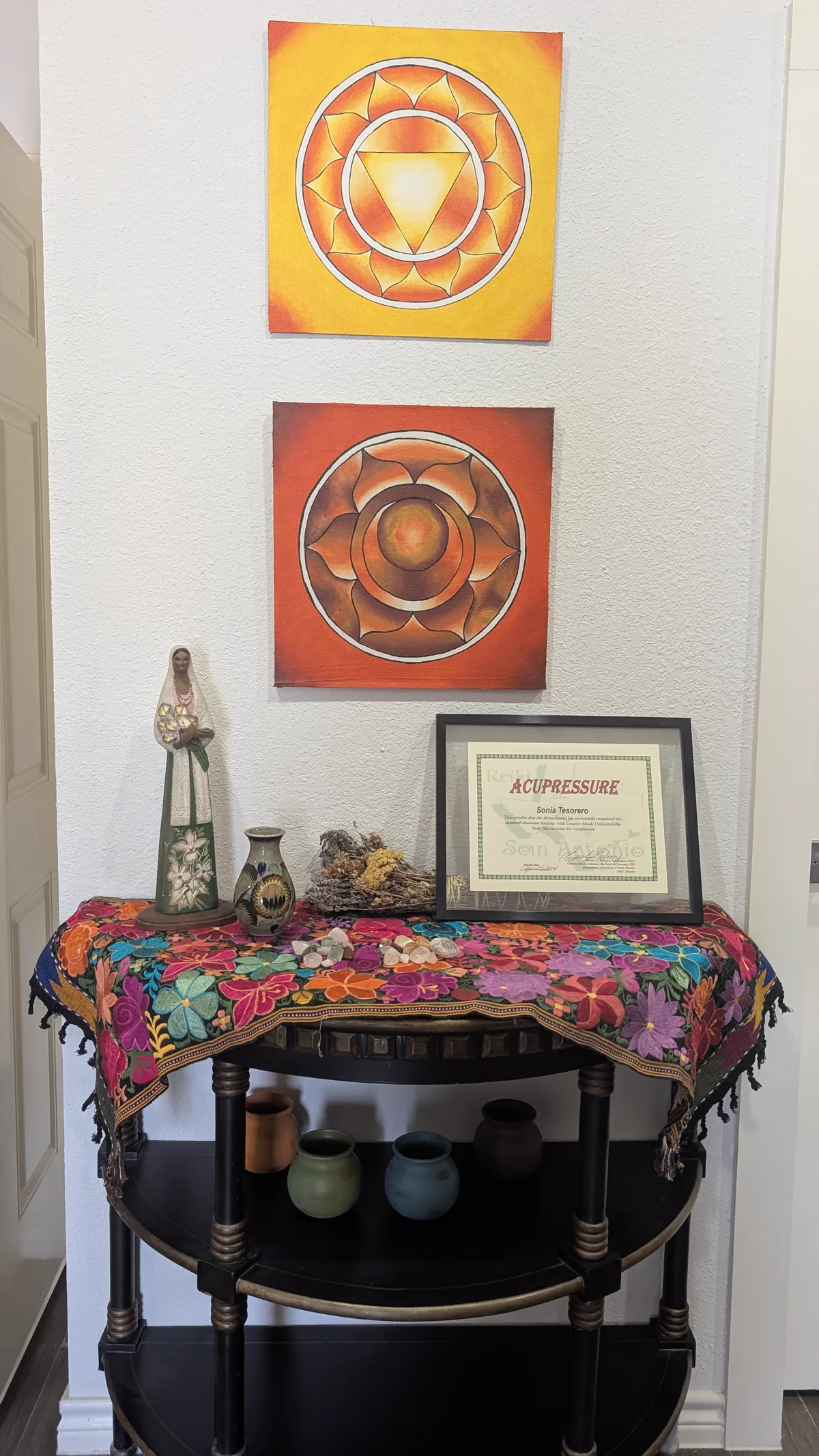 Artwork, dried flowers, pottery, stones and a certificate displayed inside Madre Tierra