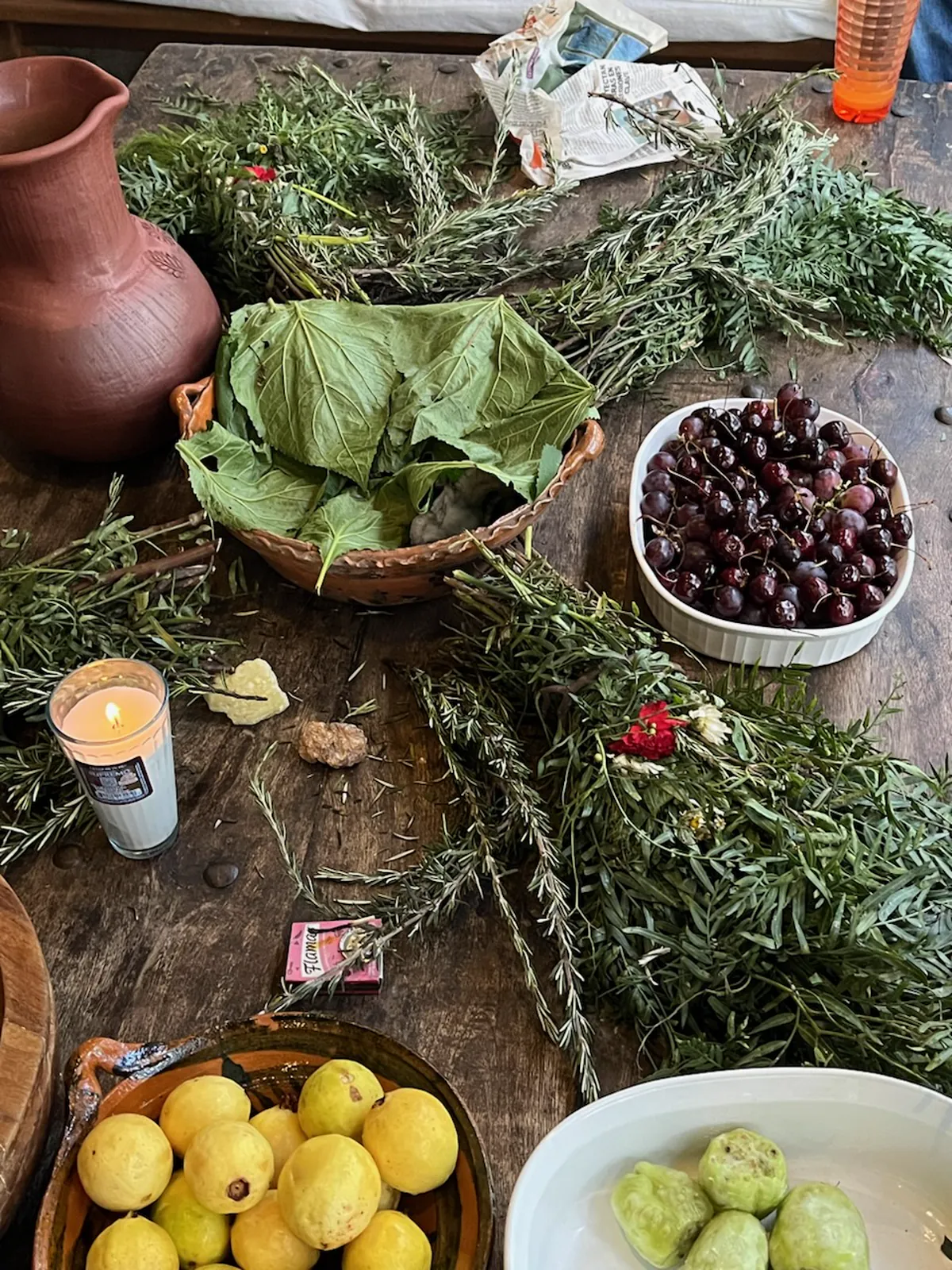Herbs, clay vessels and natural materials arranged on a rustic table in Mexico.